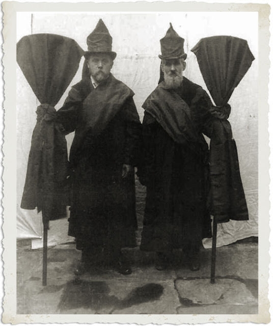Professional Mourners known as 'Mutes' were hired to walk behind the hearse in Victorian times. They wore black draped hats and coats and carried draped banners and they bore a suitably dignified, somber countenance. 